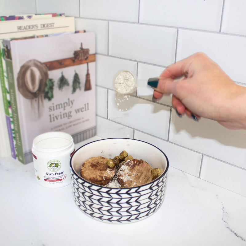 Person scooping food from a bowl with a spoon, books in the background